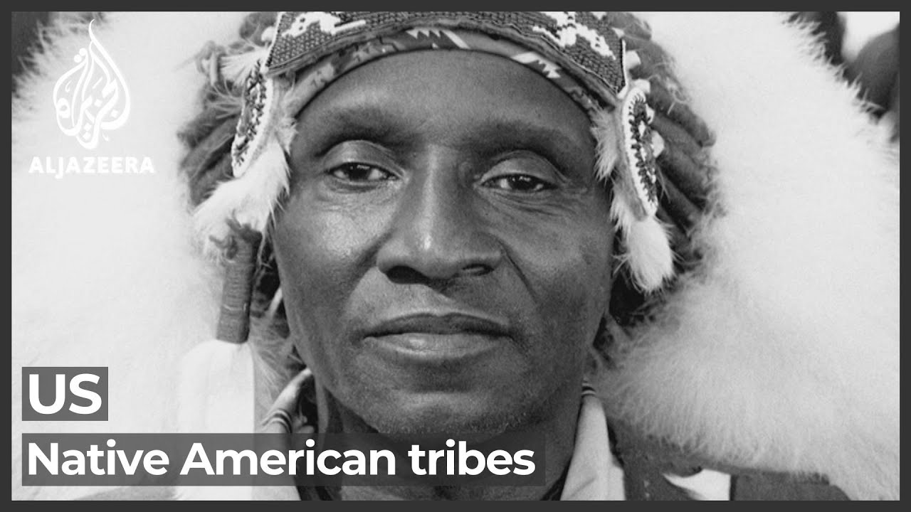 An Afro-Indigenous elder wearing a traditional feathered headdress