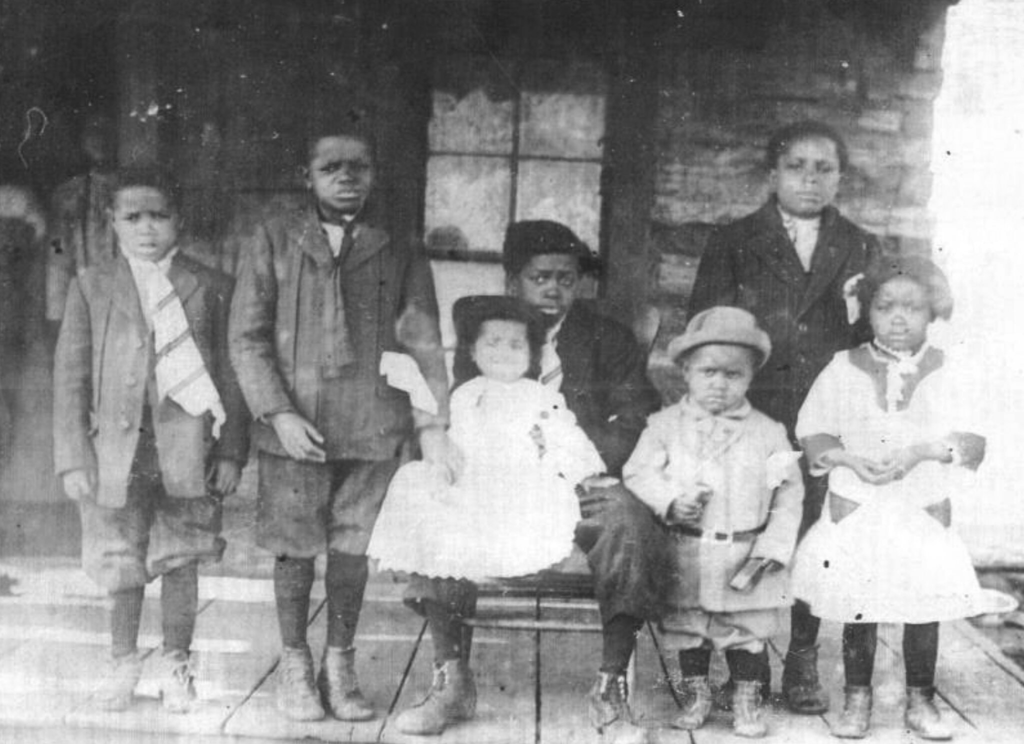 An Afro-Indigenous family photographed on a porch in Indian Territory in the early 1900s