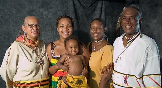 A modern Mashpee Wampanoag family of Afro-Indigenous heritage in traditional dress